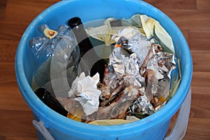 Trash bin with leftover food and chicken bones, close-up