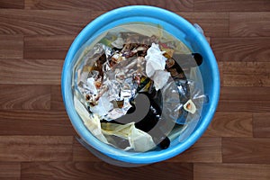 Trash bin with leftover food and chicken bones, top view