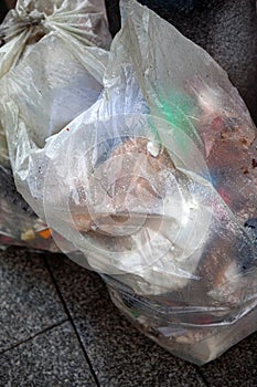 Trash can on a sidewalk in the rain