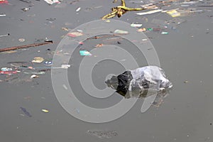 Trash and garbage floating on the surface of the water, causing sewage