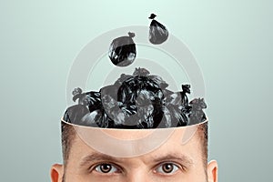 Trash in the head, a man`s head is open instead of a brain trash bags. Creative background, unnecessary information, useless