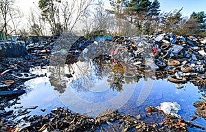 Trash piles next to pooling water