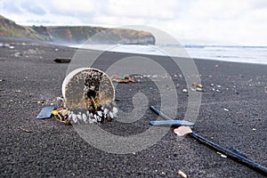 Trash in the sand, plastic waste by the ocean, sad and unsustainable photo