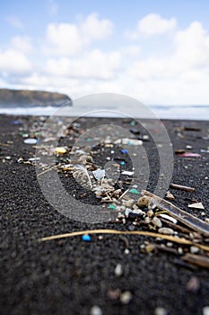 Trash in the sand, plastic waste by the ocean, sad and unsustainable photo