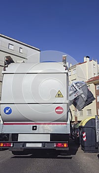 Trash truck collecting urban paper container