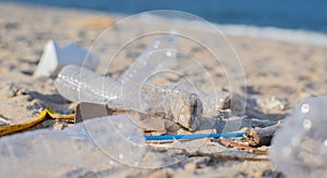 Trash and used plastic bottles on the beach. Environmental pollution. Ecological problem
