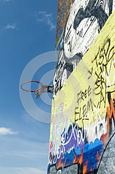 Trashed basketball hoop on graffitti wall photo