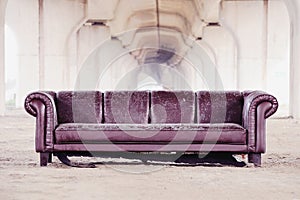 Trashed sofa under overpass, design architecture