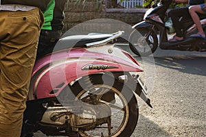 Trashy hipster pink scooter reflecting sunlight on a sunny day