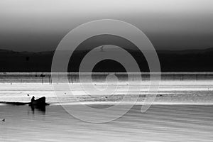 Trasimeno lake at sunset with a man on a little boat