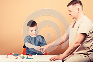 Trauma and injurie. Medicine concept. Kid little doctor sit table medical tools. Health care. Medical examination. Boy photo