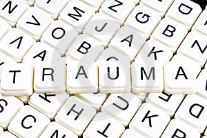 Trauma title text word crossword. Alphabet letter blocks game texture background. White alphabetical letters on black