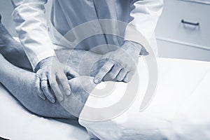 Traumatologist orthopedic surgeon doctor examining patient photo