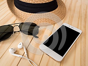 Travel accessories concept. Smartphone, earbuds, sunglasses, hat