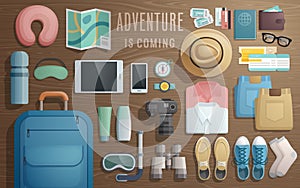 Travel accessories prepared for the trip on wooden background.