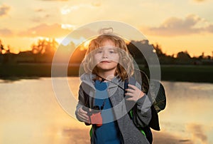 Travel and adventure concept. Little child boy tourist explorer with binoculars on nature. Discovery, exploring and