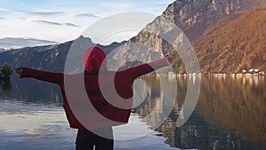 Travel adventure lifestyle. Woman raise hands up in front of Alpen mountains at sunset. Picturesque view and romantic