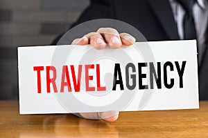 Travel agency, message on white card and hold by