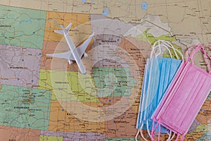 Travel air vacation during the covid-19 coronavirus quarantine with airplane model, face mask on map of the United States