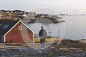 Travel in arctic landscape nature with icebergs. Greenland tourist man explorer. tourist person looking at amazing view