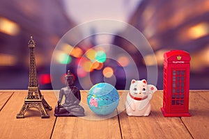 Travel around the world concept. Souvenirs from around the world on wooden table over city bokeh background