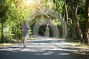 Travel asia woman standing on forest trail and looking away. Female with backpack on hike in nature