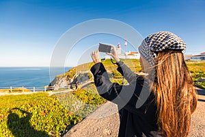 Travel asia woman taking photo on sea cliff