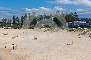 Travel background of picturesque sandy beach with incidental people