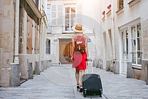 Travel background, woman tourist walking with suitcase on the street in european city, tourism