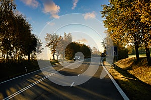 Travel with beautiful European driving routes, highways and cars and both sides with big trees changing color in autumn