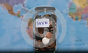 Travel budget concept. Money saved for vacation in glass jar on world map background, copy space. coins for big