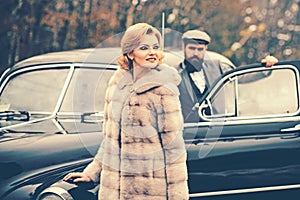 Travel and business trip or hitch hiking. Bearded man and sexy woman in fur coat. Retro collection car and auto repair