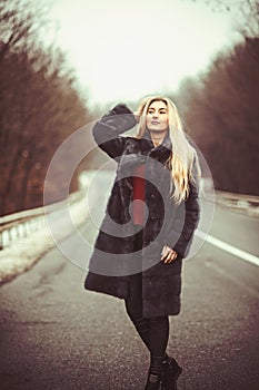 Travel and business trip or hitch hiking. sexy woman in fur coat. luxury woman with long blond hair
