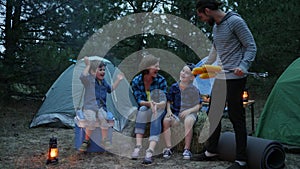 Travel in camp, mother, father and sons on rest in forest, mom, children and dad beside balefire, family evening picnic