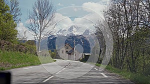 Travel by car. Car ride on beautiful countryside road with beautiful mountains landscape. View through the glass from a