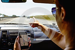 Travel in car concept, girl shows smartphone in her hand with opened gps navigation app