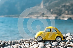 Travel car concept. Toy yellow car moves on against the backdrop of nature. Driving, adventure, discovery idea