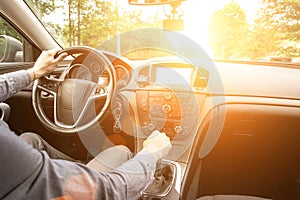 Travel car trip on road at sunset. Happy young man have fun driving inside vehicle in summer sunny day. Driver ride vacation