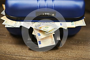 Travel case full of euro and us dollars banknotes, cash transaction or payment concept