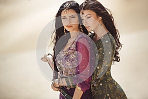 Travel concept. Two gordeous women sisters traveling in desert. Arabian girls.