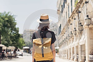 Travel concept, beautiful traveler woman walking in Corfu old town during vacation, cheerful student girl traveling abroad