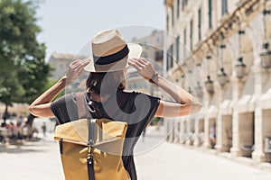 Travel concept, beautiful traveler woman walking in Corfu old town during vacation, cheerful student girl traveling abroad