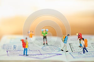 Travel Concept. Close up of group of traveler miniature figure with backpack walking and standing on passport with immigration
