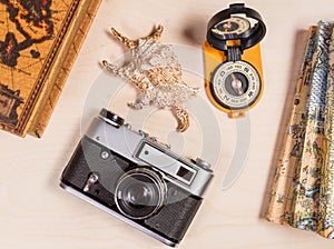 Travel concept. Compass, retro photocamera and cockleshell on a wooden backgroun