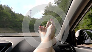 Travel concept with convenience - female legs on car panel. Window and female legs with pedicure close-up against the