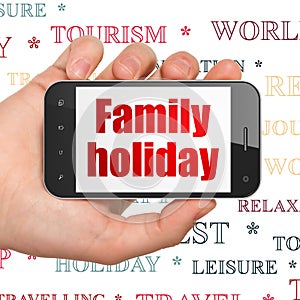 Travel concept: Hand Holding Smartphone with Family Holiday on display