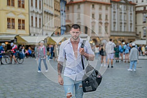 Travel concept. Handsome young man on business trip walking with his luggage on street. Travelling businessman.