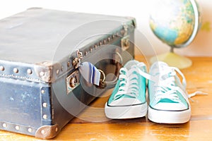 Travel concept with holiday suitcase, shoes and globe