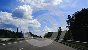 Travel concept. Landscape from a fast moving car. View from the car window to the roadside and fields on a summer or