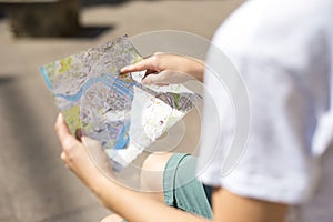 Travel concept photo with map of old european town and woman`s finger